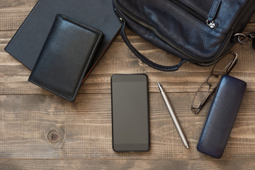 Laptop shoulder bag, mobile, notebook, pen and mens accessories for business on board. Top view. Flat lay.