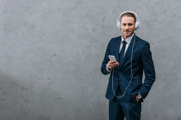 Wall Mural - young businessman listening music with headphones and smartphone