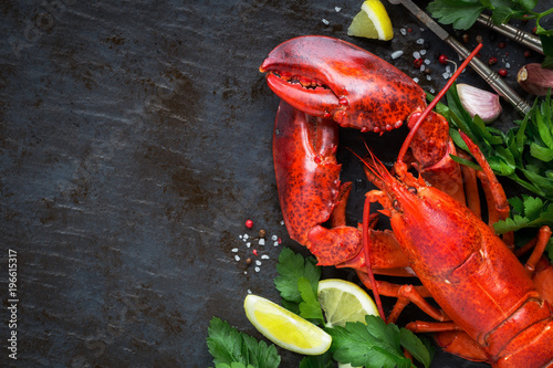 Fotografía Whole red lobster with fresh parsley, slices of lemon, garlic, salt and pepper beans
