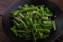 Stir Fry Green Beans On Black Bowl On Brown Wooden Background
