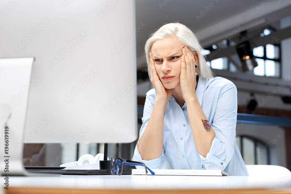 Ból głowy i zmęczenie w pracy.
Zmęczona kobieta pracuje przy komputerze.
 - obrazy, fototapety, plakaty 
