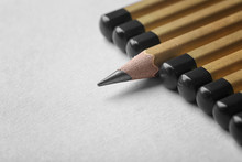 One Pencil Standing Out From Others On Color Background. Difference And Uniqueness Concept
