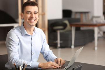 Canvas Print - Portrait of young man working in office