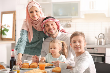 Wall Mural - Happy Muslim family having breakfast together at home