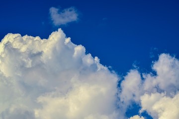 white cumulus clouds on a clear blue sky
