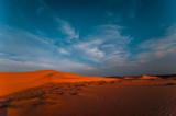 Fototapeta  - Lonely sand dunes under amazing evening sunset sky at drought desert landscape. Global warming concept