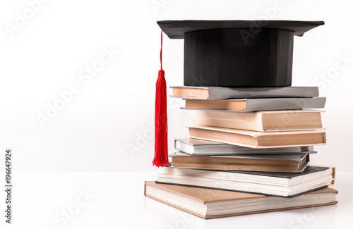 Fotografía Square academic hat on stack of different books isolated on white