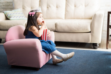 Poster - Baby with princess crown watching tv at home