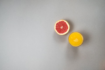 Wall Mural - Citrus slices orange and grapefruit  with juice on gray background with copyspace. Flat lay, top view