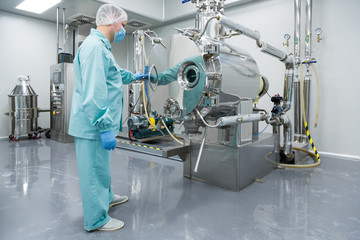 Poster - Pharmaceutical factory man worker in protective clothing working on equipment in sterile working conditions