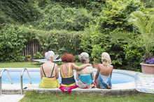 Senior Women Friends Sitting In Swimming Pool