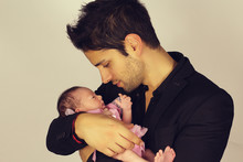 Handsome Young Father Holding His Young Baby Girl On A White Background 