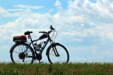 Motorized Bicycle On Green Grass Against Blue Sky Background