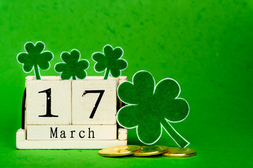 Wall Mural - Block calendar for St Patrick's Day, March 17, with green clover leaf, green water and gold bitcoin on bright green Mulberry paper background