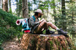 © BONNINSTUDIO/Stocksy - Young hiker man writing in a notebook sitting on an old big trunk.