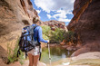 © Brocreative - Rear view of a Woman hiking to a waterfall in a red rock canyon