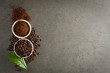 Coffee beans and ground powder with leaf on stone background. Top view with copy space
