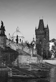 Fototapeta Miasto - Black-and-white photograph of the Charles bridge with retouch antique. Attraction in the historical centre of Prague, photo from the river