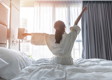 Easy Lifestyle Asian Woman Waking Up From Good Sleep In Weekend Morning Taking Some Rest, Relaxing In Comfort Bedroom At Hotel Window, Having Happy Lazy Day Enjoying Work-life Quality Balance Concept