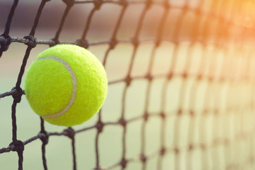close up tennis ball hitting to net on blur background