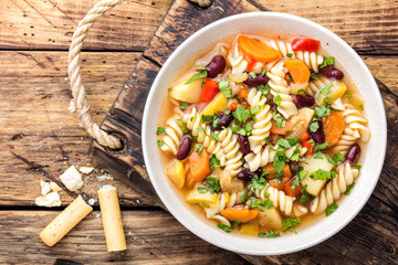 Minestrone soup. Vegetable soup with fresh tomato, celery, carrot, zucchini, onion, pepper, beans and pasta. Italian cuisine dish