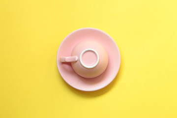 Pink coffee cup on yellow background