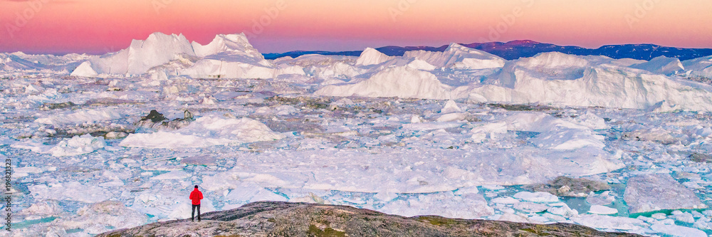 Greenland travel hiker tourist man trekking at sunset. Adventure expedition in the arctic ocean, ice floating from icebergs in ocean. Banner panorama. - obrazy, fototapety, plakaty 