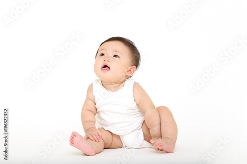 白バックの前に一人座り遊ぶ女の子の赤ちゃん Stock Photo Adobe Stock