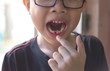 young asian boy loosing milk tooth