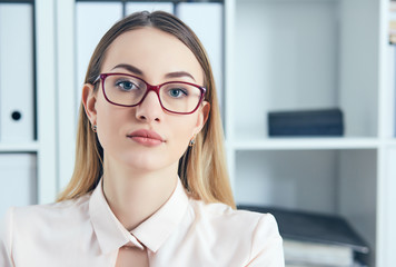 portrait of caucasian attractive business woman in glasses at office.