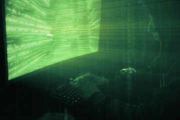 Poster - a man hacker in a hood in a dark room works with the program code