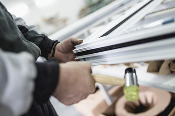 Wall Mural - Manual worker assembling PVC doors and windows. Manufacturing jobs. Selective focus. Factory for aluminum and PVC windows and doors production.