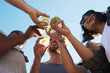 © pressmaster - Happy young friends toasting with refreshing drinks under blue sky on summer day