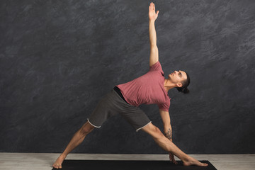 Man stretching hands and legs at gym