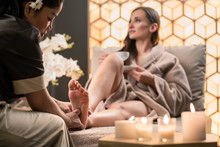 Professional Wellness Therapist Massaging The Foot Of A Female Client In Asian Beauty Center