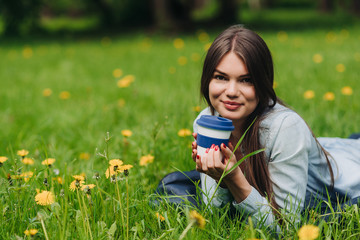 Woman with takeaway drink in park