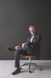 © Yakobchuk Olena - Full length portrait of happy mature male sitting on comfortable seat. Glad resting employer concept