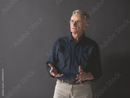 Cuadros en Lienzo Portrait of senior male expressing thoughtfulness while flourishing arms