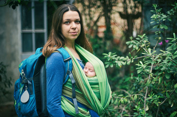 Wall Mural - A young mother with a baby in a sling is walking in the jungle