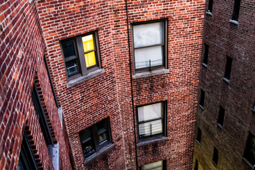 Illuminated brick apartment condo building architecture in Fordham Heights center, Bronx, NYC, Manhattan, New York City with fire escapes, windows, ac units in morning, evening, night