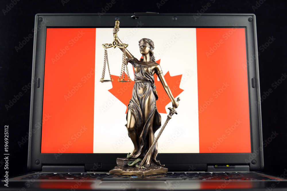Symbol of law and justice with Canada Flag on laptop. Studio shot.