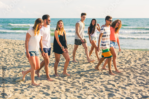 Foto Multiracial group of friends walking on the beach