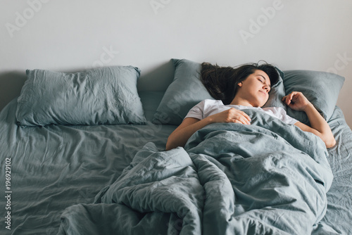 woman sleep in bed with gray sheets. happy morning concept Fototapete
