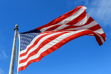 USA flag waving against clear blue sky on bright sunny day