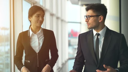 Wall Mural - The businessman and a businesswoman walking in the office. slow motion