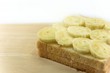 The fresh bnanas on bread slice on the morning,placed on the wooden board is ready to eat.