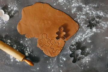 Sticker - Ingredients for cooking Christmas gingerbread cookies top view. Sheet of dough with forms for cutting cookies on dark background