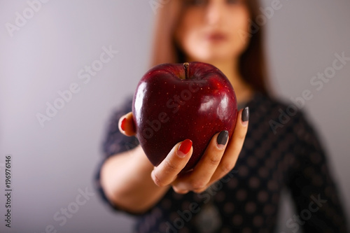 Fotografía A red ripe apple in a beautiful female hand