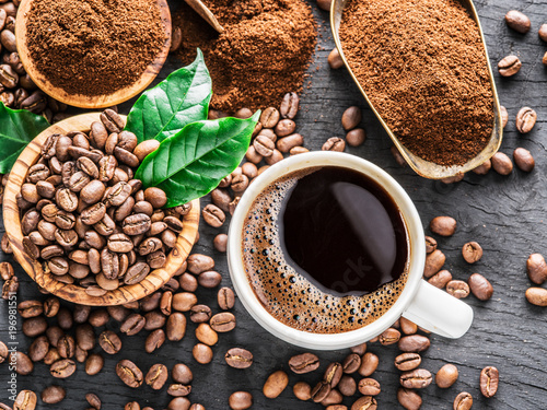 Cuadros en Lienzo Roasted coffee beans, ground coffee and cup of coffee on wooden table
