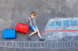 © Irina Schmidt - Little kid boy having fun with fast train picture drawing with colorful chalks on asphalt